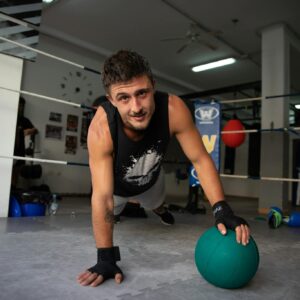 Man in Black Tank Top and Black Shorts Holding Blue Ball